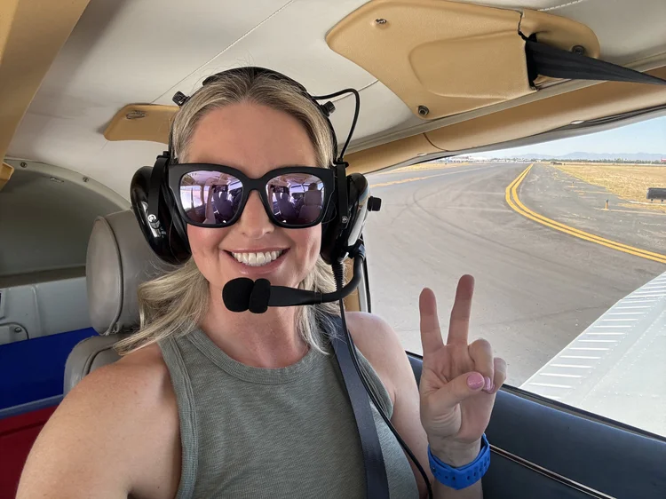 A smiling SG Flight School student in the cockpit before takeoff